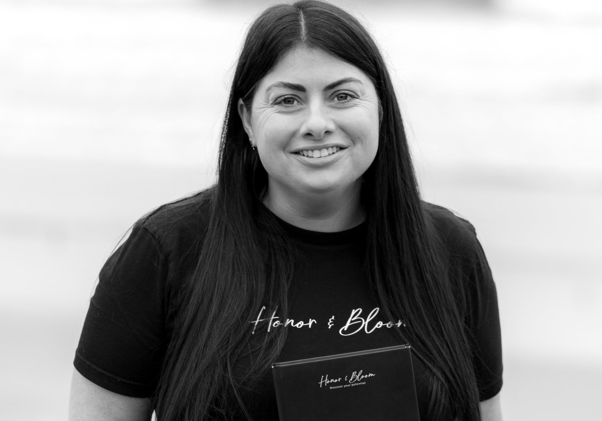 Person wearing a black t-shirt with 'Honor & Blood' branding against a light background