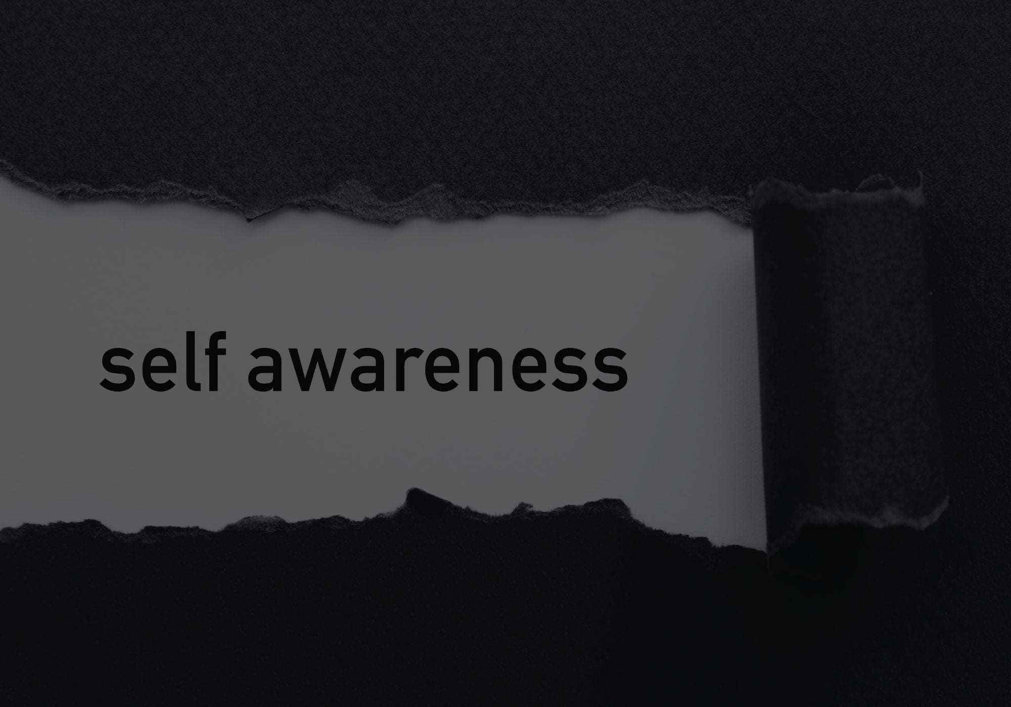 Torn piece of paper with the word 'self awareness' on a black background